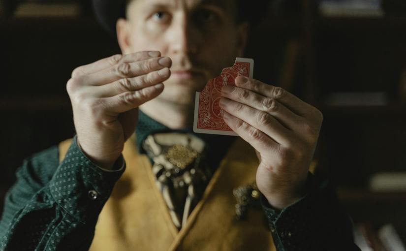 photo of a man doing a card magic trick