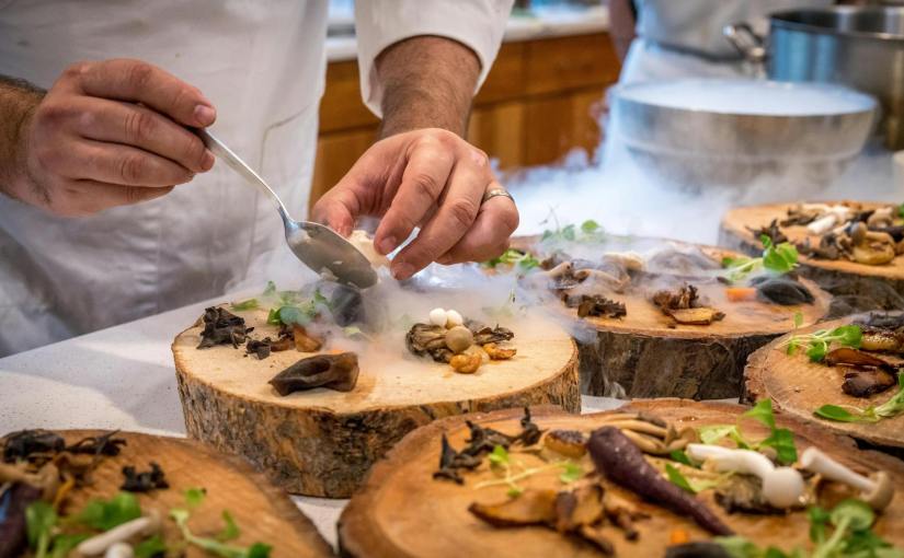 chef preparing vegetable dish on tree slab
