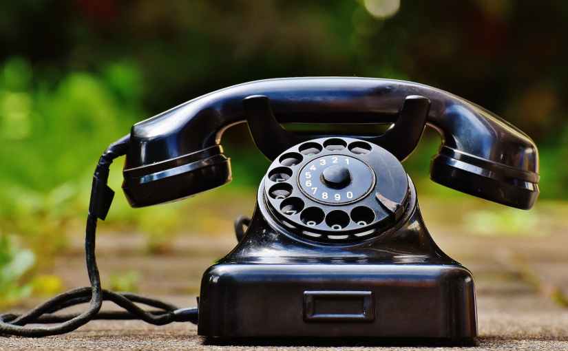 selective focus photography of black rotary phone