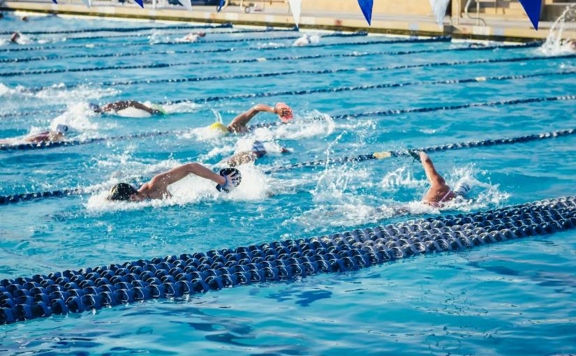 people swimming in an olympic swimming pool