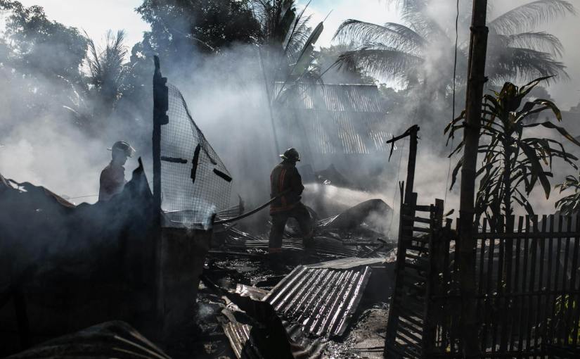 silhouette of fireman holding hose