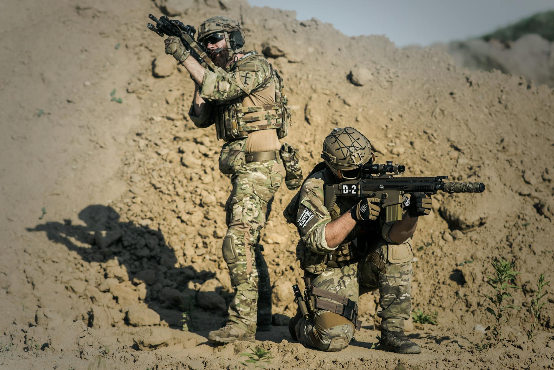 two men in army uniforms with guns