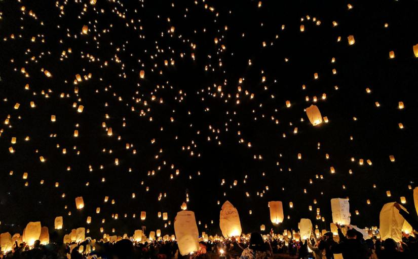 group of people throwing paper lantern on sky during night