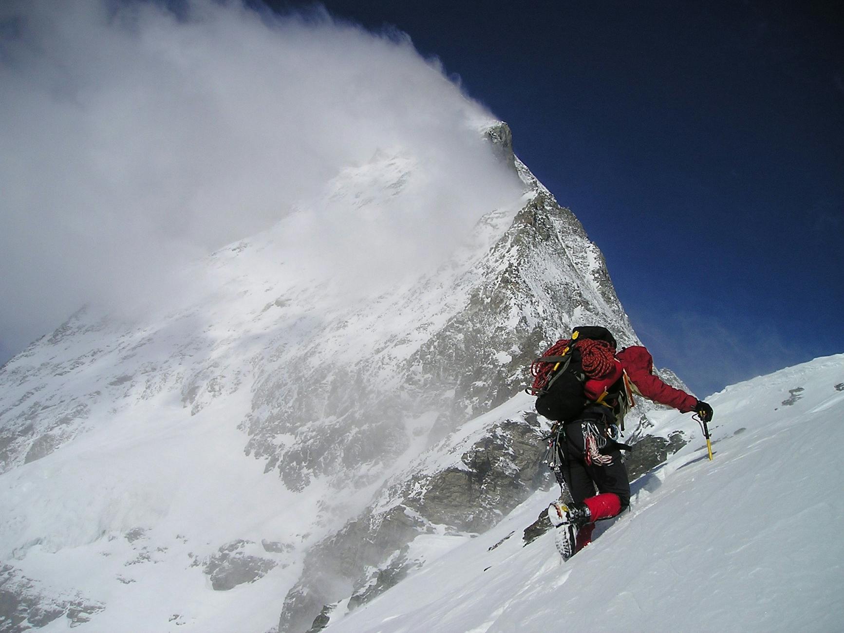 person climbing glacier mountain during day