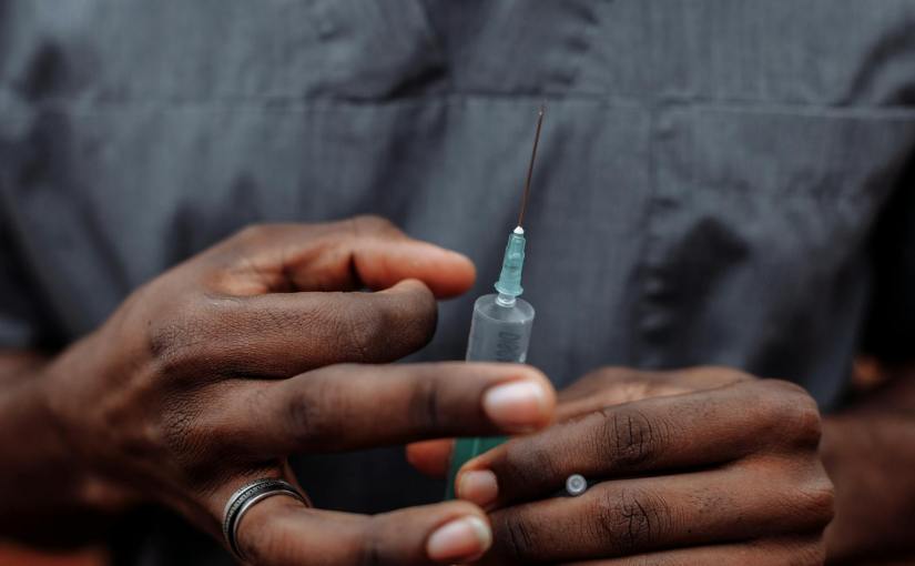 a person holding a syringe with needle