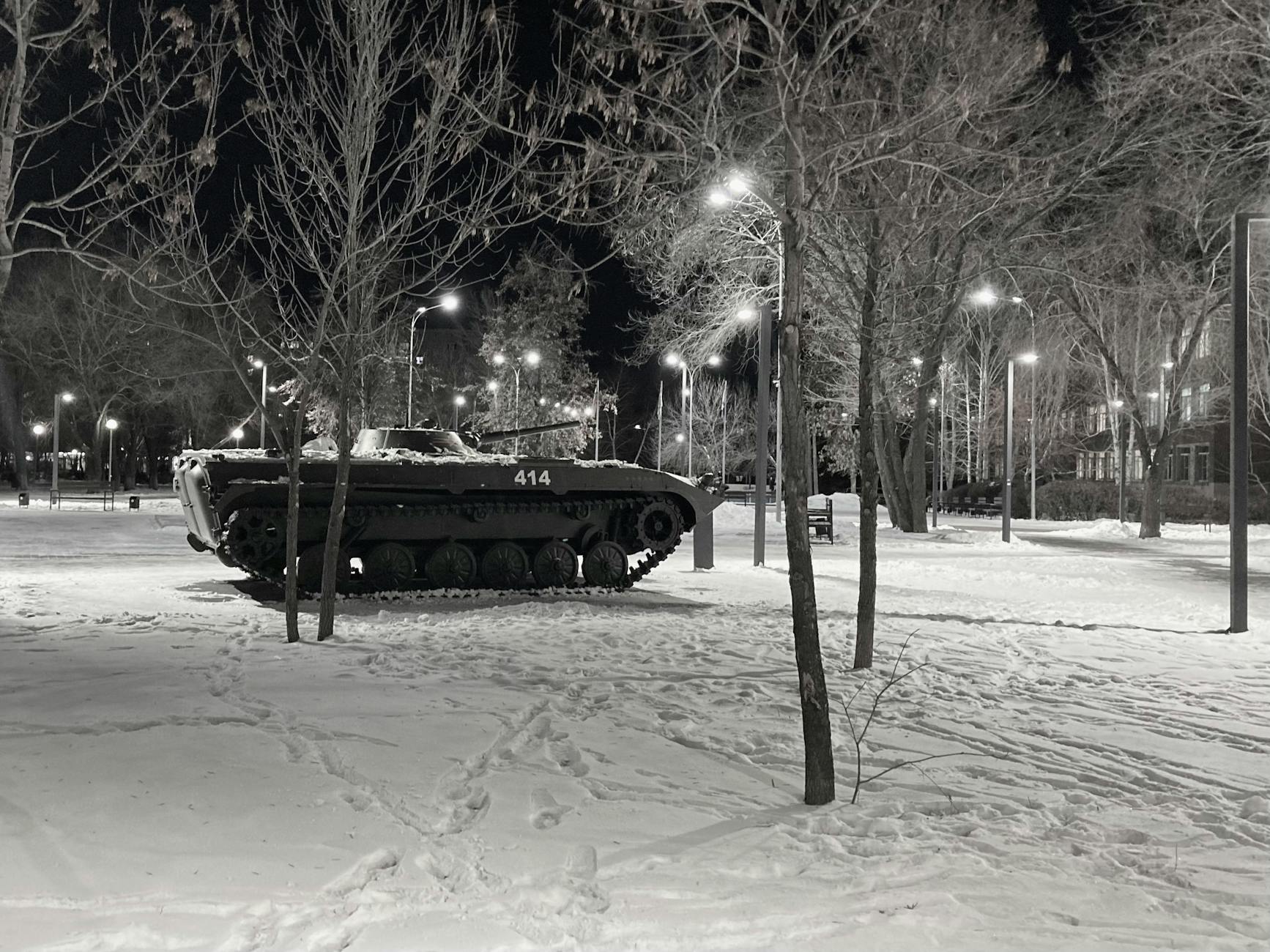 grayscale photo of a tank near trees